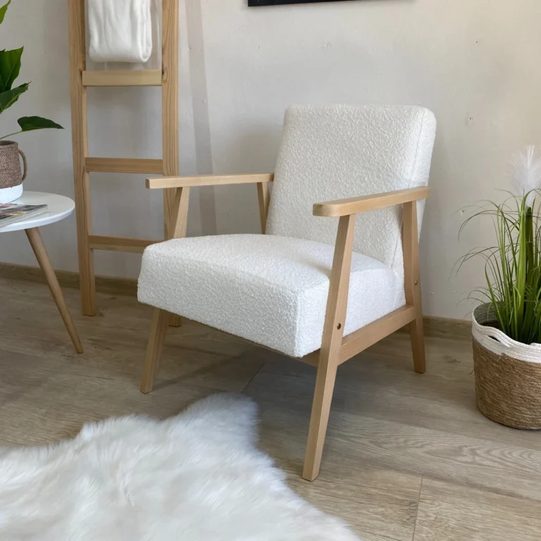 White boucle upholstered armchair in bright interior with table and plant